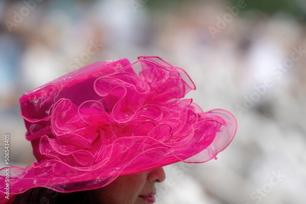 Obraz An attendee at a horse race, wearing a fancy hat.