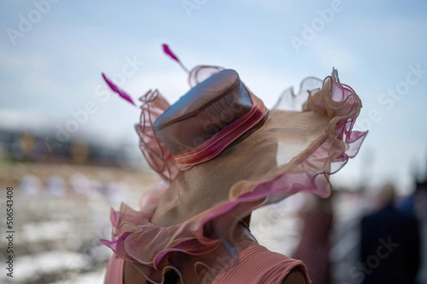 Obraz An attendee at a horse race, wearing a fancy hat.