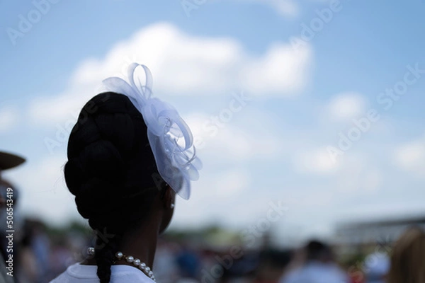 Obraz An attendee at a horse race, wearing a fancy hat.
