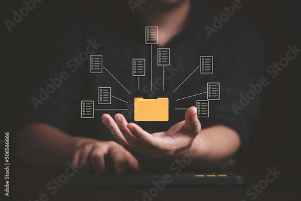 Fototapeta Businessman holding  virtual yellow folder and document for online approve paperless quality assurance and ERP management concept.