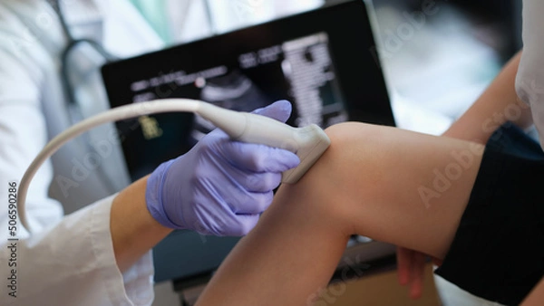Fototapeta Ultrasound procedures of knee joint of small child in hospital