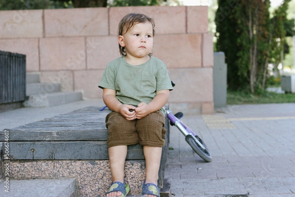 Fototapeta The boy sat sadly alone on the bench