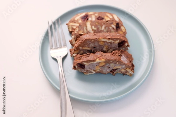 Fototapeta Homemade mosaic chocolate biscuit cake served in a blue plate, selective focus. It is called "Mozaik Pasta" in Turkish. That is texture of it not grain. Traditional Turkish dessert.