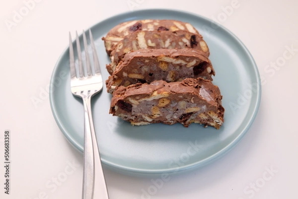 Fototapeta Homemade mosaic chocolate biscuit cake served in a blue plate, selective focus. It is called "Mozaik Pasta" in Turkish. That is texture of it not grain. Traditional Turkish dessert.