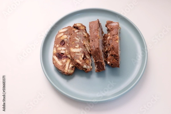 Fototapeta Homemade mosaic chocolate biscuit cake served in a blue plate, selective focus. It is called "Mozaik Pasta" in Turkish. That is texture of it not grain. Traditional Turkish dessert.