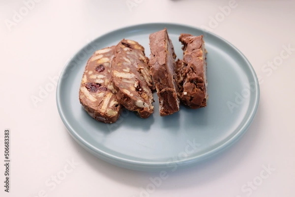 Fototapeta Homemade mosaic chocolate biscuit cake served in a blue plate, selective focus. It is called "Mozaik Pasta" in Turkish. That is texture of it not grain. Traditional Turkish dessert.