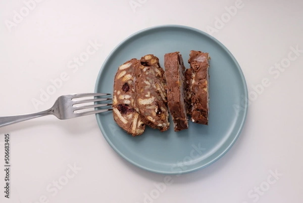 Fototapeta Homemade mosaic chocolate biscuit cake served in a blue plate, selective focus. It is called "Mozaik Pasta" in Turkish. That is texture of it not grain. Traditional Turkish dessert.