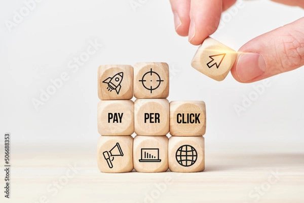 Fototapeta Concept Pay per click or PPC. Person stacks wooden cubes from text and icons.