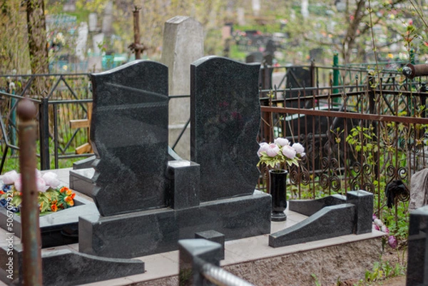 Obraz Series of monuments made of black gabbro-diabase granite on the graves of the deceased in a cemetery in Eastern Europe
