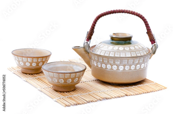 Obraz Closeup of teapot and teacup set Japanese style put on bamboo mat isolated on white background.