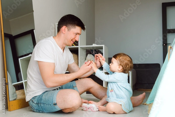 Obraz Brunette father spent time playing with daughter taking hands together and look each other