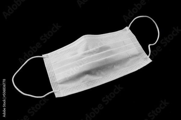 Obraz Medical mask isolated on black background. Respirator on the table. Coronavirus mask. 