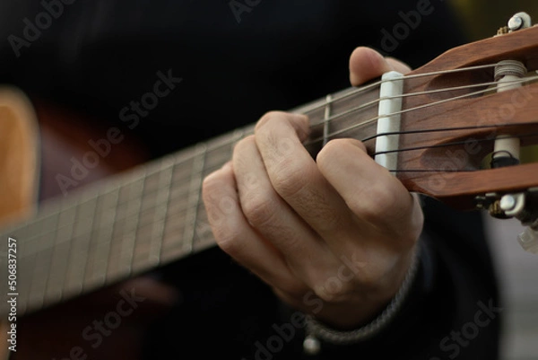 Obraz The guy plays the old guitar. Guitar in hands. Close-up strings. 