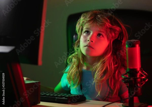 Fototapeta Child with pc computer at night. Overuse and addiction kids from gadgets. School, study, online learning concept. Schoolboy typing on keyboard.