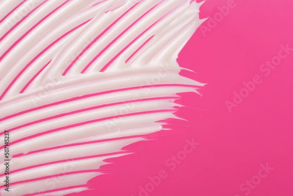 Fototapeta Abstract smear of white cosmetic cream on the pink background,abstract form.