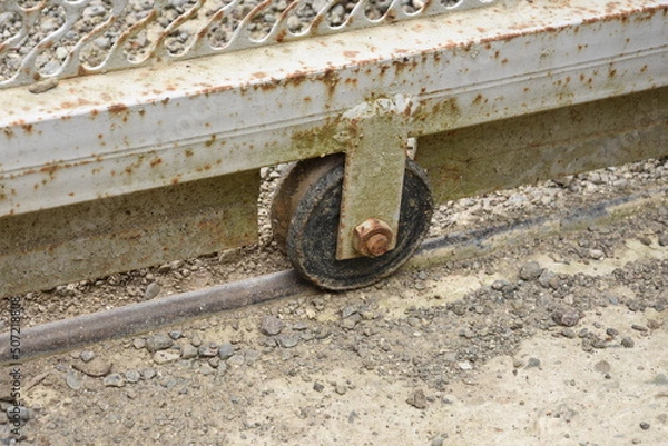 Fototapeta Old used aged weathered sliding gate roller. 