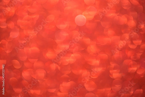 Fototapeta Red bokeh background. Festive Christmas shiny background. Glittering red light.