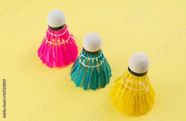 Fototapeta Bright shuttlecocks for badminton on a yellow background. Summer background.