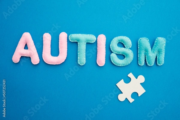 Obraz Autism awareness concept with puzzle and word autism on blue background.