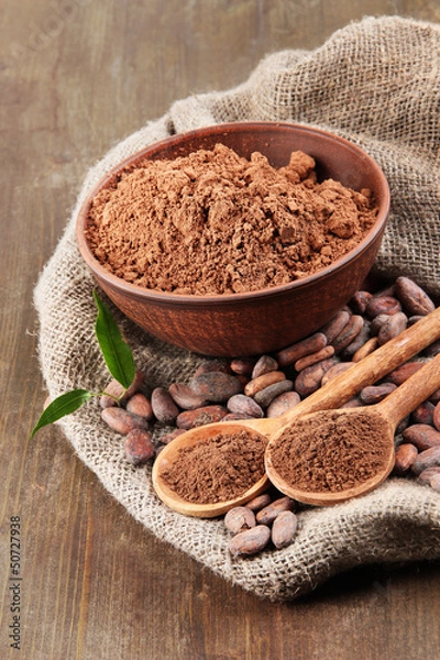 Fototapeta Cocoa powder and cocoa beans on wooden background