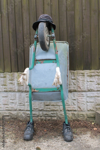 Fototapeta Wheelbarrow made to look like a person, Will Barrow concept. Will Barrow is an accomplished singer-songwriter, composer, and educator