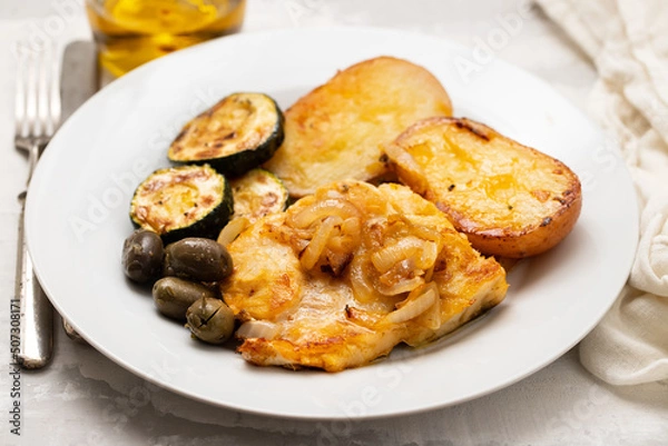 Obraz fried meat with potato, courgette and olives on the plate