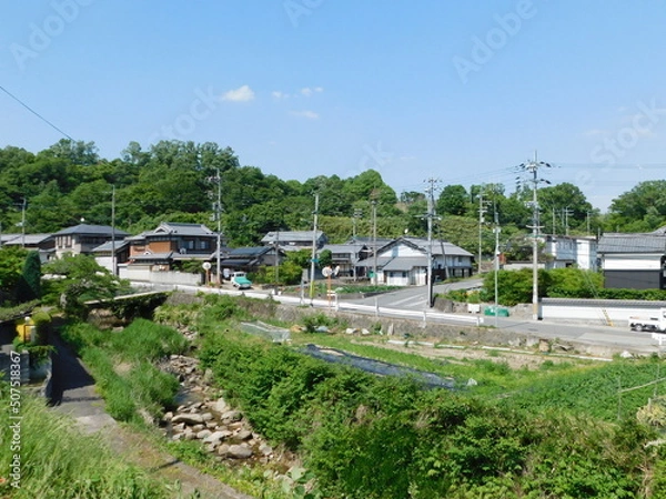 Fototapeta 大阪府茨木市佐保の集落の中を流れる佐保川(2022年5月撮影)