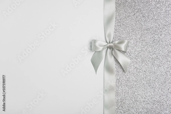 Obraz Shiny silver gift ribbon bow on gray background