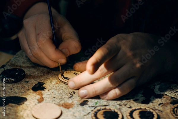 Fototapeta People draws a pattern on a wooden blank. Handmade