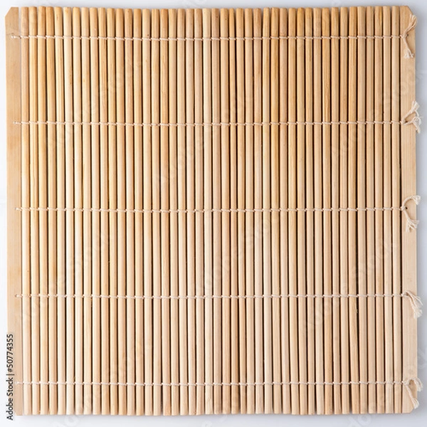 Fototapeta Bamboo mat for sushi. Straw colored background