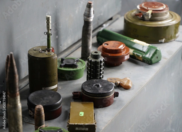 Fototapeta Lots of shells and rockets of war in Ukraine. Grenades, ATGMs, cruise missiles. Anti-personnel mine. Territory cleared. Demining by troops of the territory.