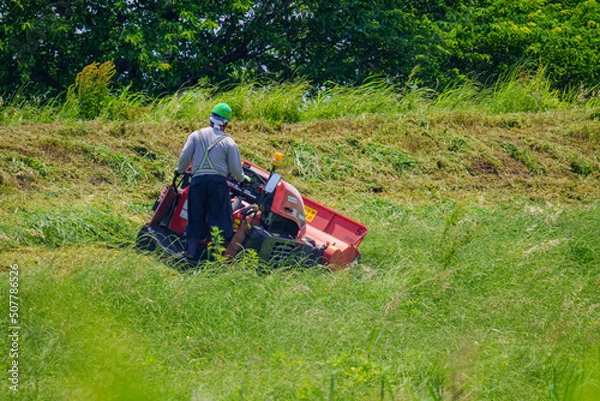 Obraz 土手沿いの雑草を刈り取る作業中