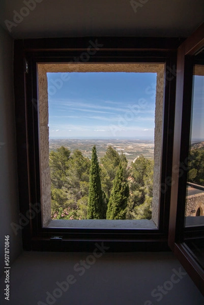 Fototapeta A wooden window seen from inside a room at the Parador de Jaen hotel. Beautiful views of the city of Jaen, Spain.