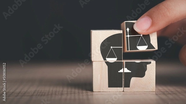 Fototapeta Ethics inside human mind, Business ethics concept. Hand hold ethics inside a head symbols in wooden cubes on dark background with copy space.