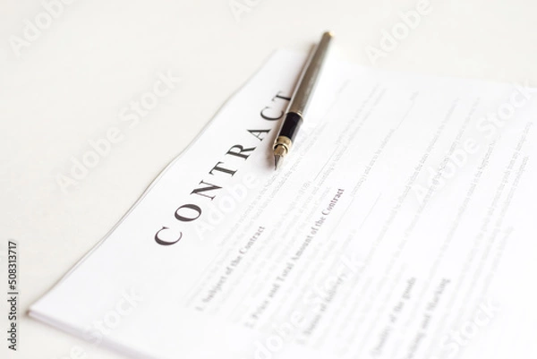 Fototapeta Pen for signing the contract. The pen and contract are on the laptop.