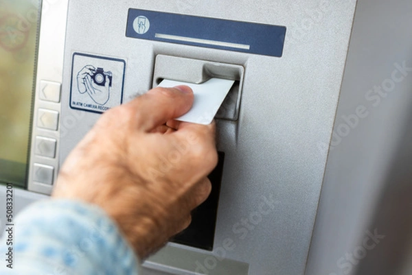 Obraz Male hand inserting ATM card into ATM bank machine