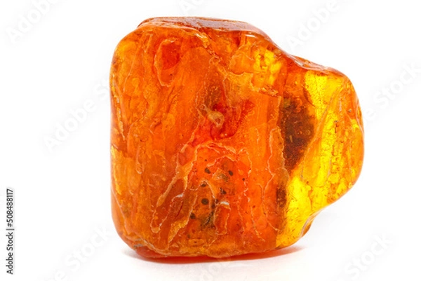 Fototapeta Yellow piece of amber on a white background. Natural mineral. Material for jewelry and ornaments. Sun stone. Science and geology. Fossilized resin. Semi-precious crystal