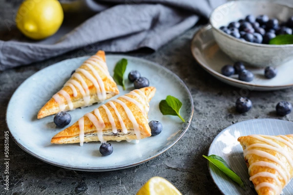 Fototapeta Blueberry puff pastry Turnovers with lemon glaze