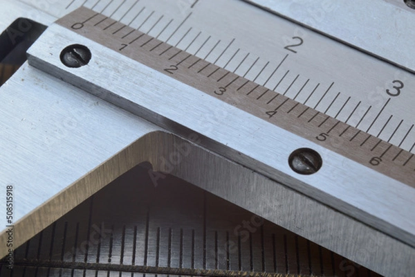 Fototapeta Accurate measuring tool caliper and metal ruler lie on top of each other. close-up.