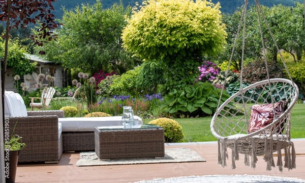 Fototapeta Photo of a modern sofa with pillows set in the garden