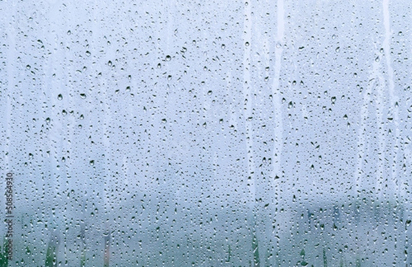 Fototapeta Rain drop on glass window at day time in monsoon season with blurred background.