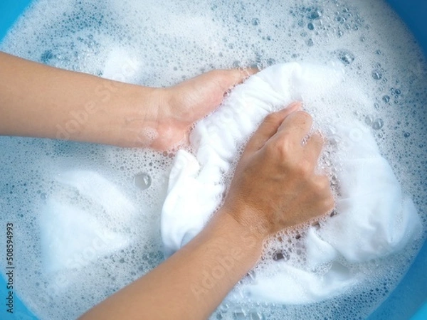 Obraz Shirt washing with detergent bubble in wash tub. top view  photo, blurred.