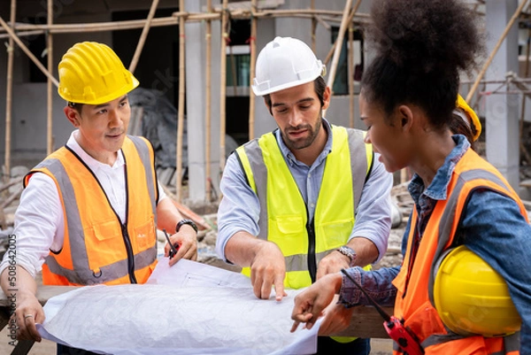 Obraz group civil engineers male female discuss inspect construction of houses in the village who responsible for exterior work build houses according standards to strong correct according designed designs