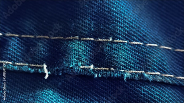 Fototapeta Close-up old work uniform with scuffs on a lowercase seam of blue denim