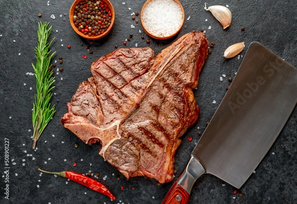 Fototapeta grilled T-bone steak or porterhouse Steak with herbs and salt on stone background