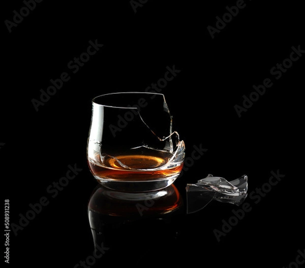 Fototapeta Broken whiskey glass isolated on black background.