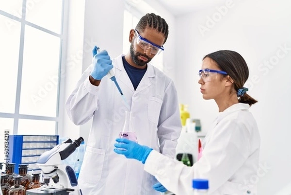 Obraz Man and woman scientist partners working using test tube and pipette at laboratory