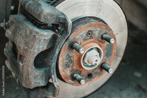 Fototapeta A rusty and old brake disc is serviced or replaced when the car is inspected by a mechanic. Safety and wear of the brake system