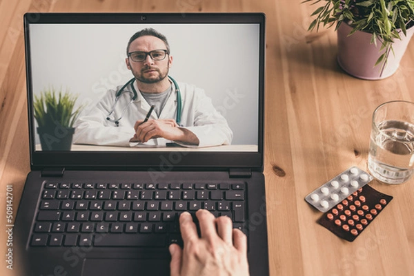 Obraz Laptop's screen with a doctor talking with a patient online. Telemedicine concept.