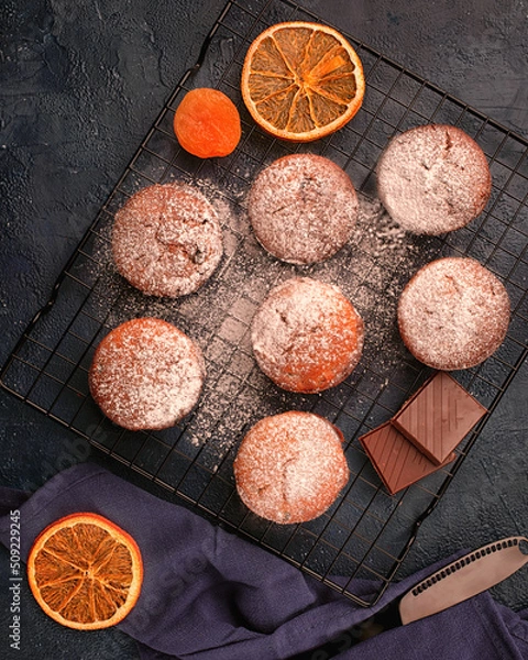 Obraz Chocolade muffins on cooling rack decorated on black background.Top view.